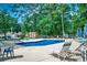 Community pool with lounge chairs, tables, and umbrellas surrounded by mature trees at 220 Gateway Dr., Little River, SC 29566
