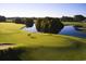 Scenic golf course view with well-manicured green, shimmering lake, and two golfers on a beautiful afternoon at 223 Atlantic Breeze St., Myrtle Beach, SC 29572