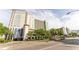 Multi-story condo building with light blue accents, surrounded by lush landscaping and palm trees at 2401 S Ocean Blvd. # 1262, Myrtle Beach, SC 29577