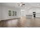 Bright living room with wood floors, a ceiling fan, and a large window overlooking the backyard at 250 Six Mile Creek Dr., Georgetown, SC 29440