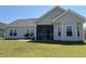 Backyard with a screened in porch and a concrete patio with chairs, surrounded by green lawn at 2594 W Shore Dr., Longs, SC 29568