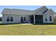Home backyard with a screened in porch and a patio with chairs, next to well maintained grass at 2594 W Shore Dr., Longs, SC 29568