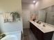 Bathroom with double sinks, ample counter space, and stylish fixtures and an adjacent tub at 2594 W Shore Dr., Longs, SC 29568