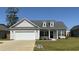 Charming single-Gathering home featuring a two-car garage, dormer windows, and manicured front lawn at 2594 W Shore Dr., Longs, SC 29568