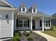 Inviting front entrance featuring a stylish front door, dormer windows, and manicured landscaping at 2594 W Shore Dr., Longs, SC 29568