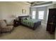 Spacious bedroom with a ceiling fan, complemented by bedside tables and a decorative armchair at 2594 W Shore Dr., Longs, SC 29568