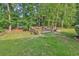 Lush backyard featuring a wooden deck, fire pit, and abundant greenery for outdoor enjoyment at 2818 Sanctuary Blvd., Conway, SC 29526