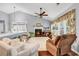 Inviting living room features high ceiling, fireplace, many windows, and cozy seating, making it a comfortable gathering space at 2818 Sanctuary Blvd., Conway, SC 29526