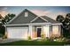 Inviting single-Gathering home boasts a two-car garage, attractive landscaping, and charming architectural details at 296 River Edge Dr., Myrtle Beach, SC 29588