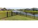 View of a backyard with wrought iron fence and a tranquil pond with a fountain, offering serene water views at 2979 Skylark Dr., Myrtle Beach, SC 29577