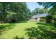 View of the backyard showcasing its expansive lawn and mature trees at 309 Otter Run Rd., Pawleys Island, SC 29585