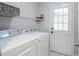 Functional laundry area with modern washer and dryer, wire shelving, and exterior access door at 309 Otter Run Rd., Pawleys Island, SC 29585