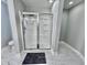 Modern glass shower enclosure with white marble tile and a dark floor mat at 309 Otter Run Rd., Pawleys Island, SC 29585