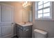 Well-lit bathroom with a vanity and a mirror, complemented by a toilet and stylish gray cabinets at 311 Six Mile Creek Dr., Georgetown, SC 29440