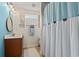 Inviting bathroom featuring rustic accents, a shower with blue-and-white curtain, and a wood-framed window at 312 Caldera Ct., Murrells Inlet, SC 29576