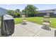 Landscaped backyard with a stone patio featuring outdoor seating and a grill at 4136 Alvina Way, Myrtle Beach, SC 29579