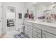 Bathroom with dual sinks, gray cabinets, and an open doorway to the closet at 4136 Alvina Way, Myrtle Beach, SC 29579