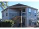 Exterior view of a two-story condo with a private balcony and staircase at 423 Tree Top Ct. # 23-B, Myrtle Beach, SC 29588
