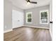 Well-lit bedroom with light-colored walls, a ceiling fan, and two windows overlooking the neighborhood at 4329 Landing Rd., Little River, SC 29566