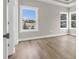 Bright bedroom with large windows offering neighborhood views and sleek hardwood floors at 4329 Landing Rd., Little River, SC 29566