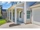 Close-up of the home's entrance showcasing a covered porch, stylish lighting, and landscaping at 4329 Landing Rd., Little River, SC 29566
