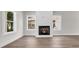 Living room featuring a cozy fireplace, neutral walls, and gleaming hardwood floors at 4329 Landing Rd., Little River, SC 29566