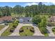 Aerial view of the home featuring manicured landscaping, a water fountain, and a lush golf course backdrop at 4709 National Dr., Myrtle Beach, SC 29579