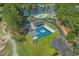 Aerial view of community amenities including a pool, lake, tennis court, and bocce ball court surrounded by greenery at 4709 National Dr., Myrtle Beach, SC 29579