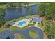 Aerial view showcasing a community pool, clubhouse, and lakefront location within a lush, green landscape at 4709 National Dr., Myrtle Beach, SC 29579