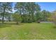 Manicured backyard with lush green grass, trees, and view of the back of the property at 4709 National Dr., Myrtle Beach, SC 29579