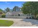 Charming one-story home with an expansive driveway, manicured lawn, and mature trees at 4709 National Dr., Myrtle Beach, SC 29579