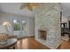 A living room featuring a stone fireplace, hardwood floors, and access to the backyard at 4709 National Dr., Myrtle Beach, SC 29579