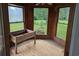 Sunroom with multiple windows showcasing backyard views and a wooden planter at 4719 National Dr., Myrtle Beach, SC 29579