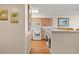 Bright kitchen featuring white appliances, wood floors and cabinets, and a laundry area at 4719 S Ocean Blvd. # 108, North Myrtle Beach, SC 29582