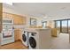 Bright, modern kitchen features a bar with front-loading washing machines looking into the living room at 4719 S Ocean Blvd. # 108, North Myrtle Beach, SC 29582