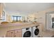 Kitchen breakfast bar features dual, front-loading washing machines overlooking the living area and beach views at 4719 S Ocean Blvd. # 108, North Myrtle Beach, SC 29582