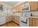 Cozy kitchen with laminate wood flooring, cream cabinets and countertops, and white appliances at 4719 S Ocean Blvd. # 108, North Myrtle Beach, SC 29582