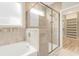 Modern bathroom featuring separate tub and shower with custom tile surround and window at 5087 Sundrop Ln., Little River, SC 29566