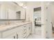 Bright bathroom featuring double vanity with granite countertops, modern lighting, and views into the main bedroom at 5087 Sundrop Ln., Little River, SC 29566