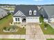 Beautiful exterior view of home with landscaped front yard, two-car garage, and a dark roof at 5087 Sundrop Ln., Little River, SC 29566