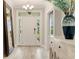 Bright foyer featuring wood floors, decorative mirror, light fixture, and white front door at 5087 Sundrop Ln., Little River, SC 29566