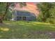 Spacious backyard features a large green lawn, trees, and a house with a covered patio at 520 Oak Pond Ct., Conway, SC 29526