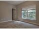 Neutral bedroom with carpet floors and a large window with blinds and views of the green trees outside at 520 Oak Pond Ct., Conway, SC 29526