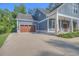 Stylish home exterior showcasing a two-car garage, a covered porch with stone accents, and manicured landscaping at 520 Oak Pond Ct., Conway, SC 29526