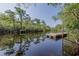 Wooden dock on a quiet lake surrounded by lush trees and clear blue skies at 520 Oak Pond Ct., Conway, SC 29526