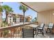 Charming balcony seating area with views of the complex, pool, and palm trees at 5515 N Ocean Blvd. N # 206, Myrtle Beach, SC 29577