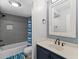 Modern bathroom with a blue vanity and a shower featuring gray tile at 5515 N Ocean Blvd. N # 206, Myrtle Beach, SC 29577