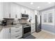Updated kitchen with stainless appliances, granite counters, and mosaic tile backsplash at 5515 N Ocean Blvd. N # 206, Myrtle Beach, SC 29577