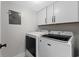 Functional laundry room with modern washer and dryer, plus overhead cabinets at 5515 N Ocean Blvd. N # 206, Myrtle Beach, SC 29577