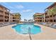 Community pool with lounge chairs and palm trees overlooking the beach and ocean at 5515 N Ocean Blvd. N # 206, Myrtle Beach, SC 29577